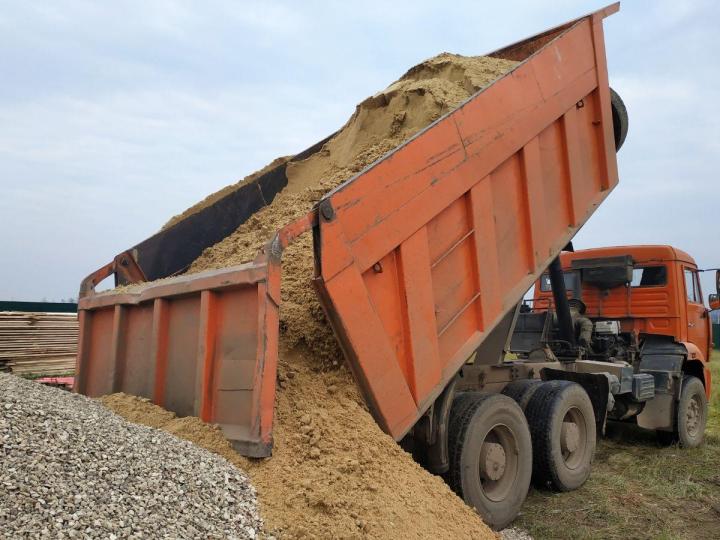 Transport et épandage de sable par camions Stone Slinger.